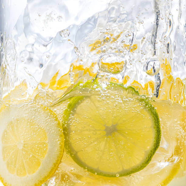Cross section view on slices of lemon and lime in sparkling water. stock photo