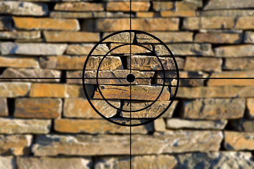 Crosshairs in front of a stone wall