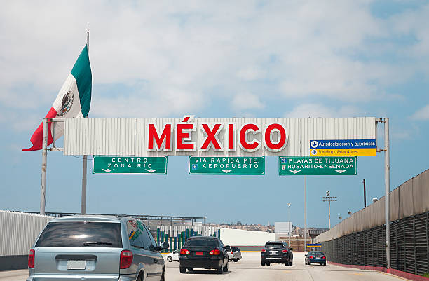 Crossing the Us - Mexico border to Tijuana A view of the highway entrance to Tijuana Baja California at the international US Border with Mexico in San Diego. geographical border stock pictures, royalty-free photos & images