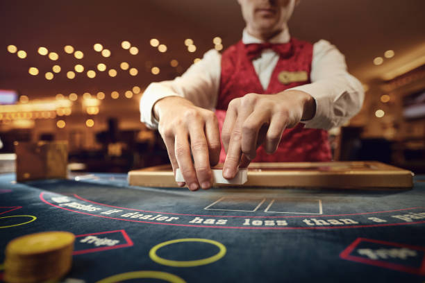Croupier holds poker cards in his hands at a table in a casino. stock photo