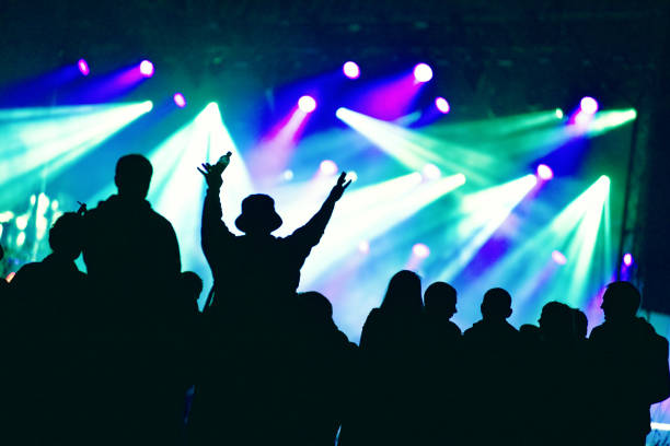 Crowd at a music concert, audience raising hands up stock photo