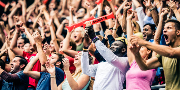 Crowd cheering for their team with arms raised Large crowd in a football stadium cheering for their team with their hands raised. match sport photos stock pictures, royalty-free photos & images