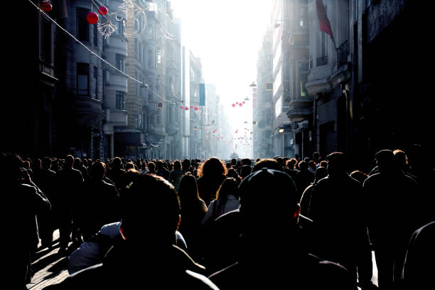 Crowd of people walking on busy street stock photo