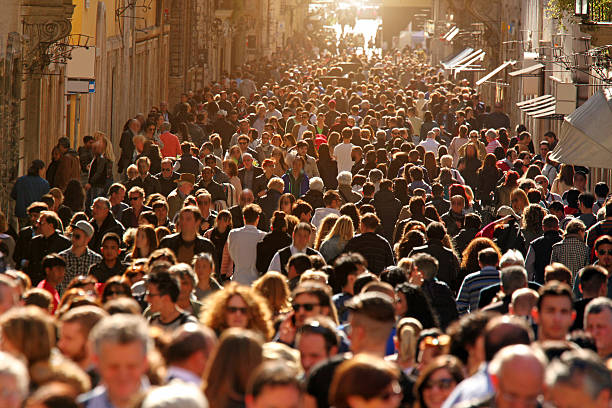 Crowd of people walking on street in downtown Rome, sunlight stock photo