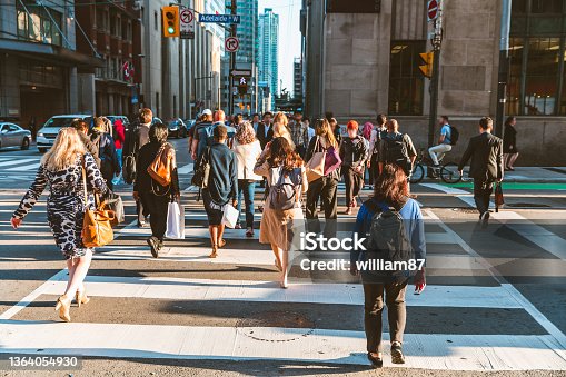 istock Crowd of unrecognisable people crossing street on traffic light zebra 1364054930