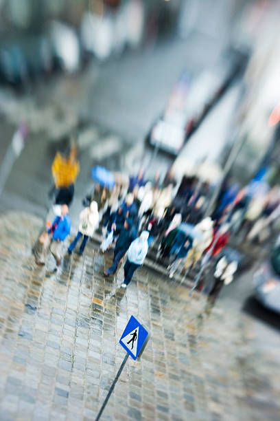 Crowd Crowd of people crossing street on rainy day yt stock pictures, royalty-free photos & images