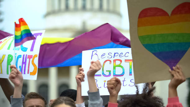 crowd raising posters zingen om lgbt-rechten te respecteren, ondersteuning voor homohuwelijk - gay demonstration stockfoto's en -beelden