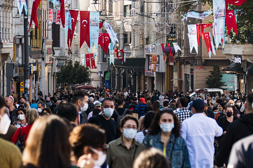 Many people walking along Istiklal street during coronavirus pandemic. Some people wearing face mask while other don't. Istanbul ,Turkey
