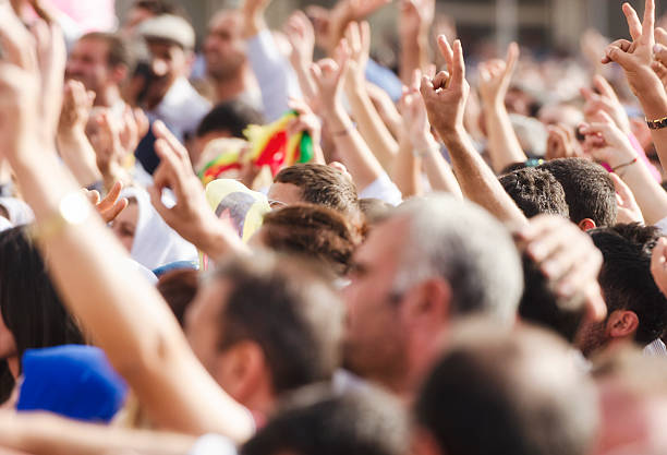 Crowds making peace sign at political rally stock photo