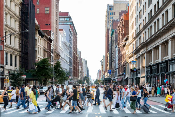 Crowds of people cross street in New York City stock photo