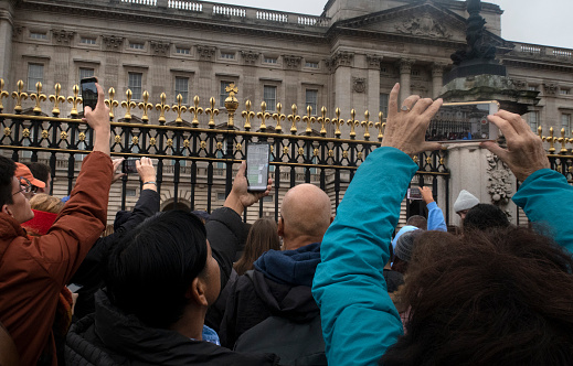 London, England - 21 August 2014: A crowd of tourists wait outside Buckingham Palace for the Changing of the Guards to start in London, England.
