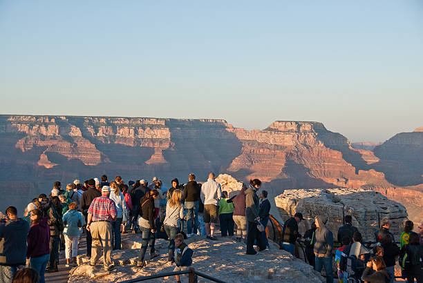 Crowds of Tourists Watch the Sunset from Mather Point Grand Canyon National Park, Arizona, USA - May 15, 2011: Tourists are watching the sun set over the Grand Canyon from Mather Point. jeff goulden rock formation stock pictures, royalty-free photos & images