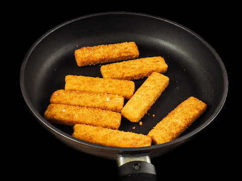 Crumbed Fish Fingers In Fry Pan Isolated On Black Stock Photo Download Image Now Istock
