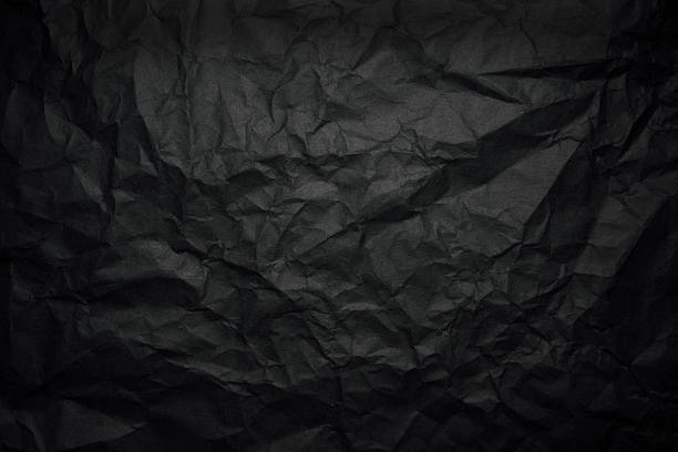 Crumpled black rice paper background with spotlight stock photo