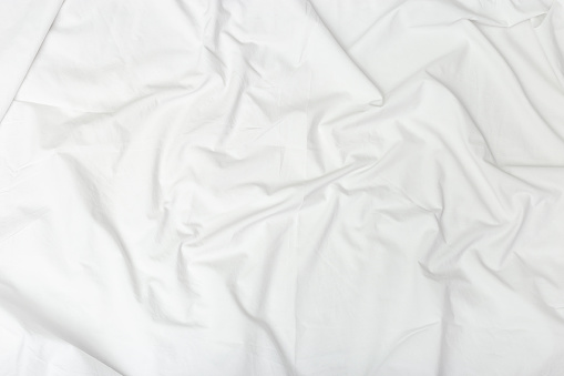 Crumpled white sheet.  Textile background. Fabric texture. Natural cotton sheet
