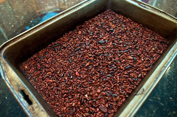 Crushed, roasted cocoa beans in a pan stock photo