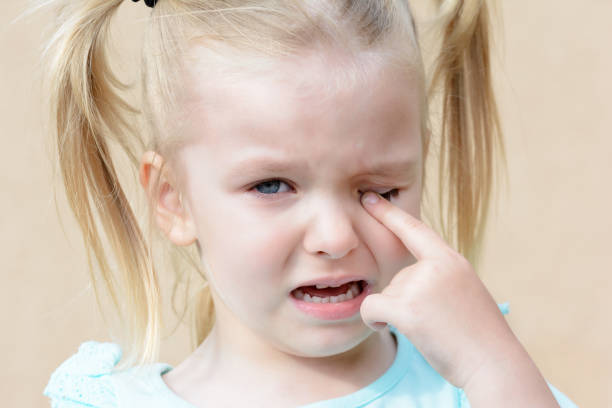 Crying baby. Hysterical girl with blond hair. Emotional photo. stock photo