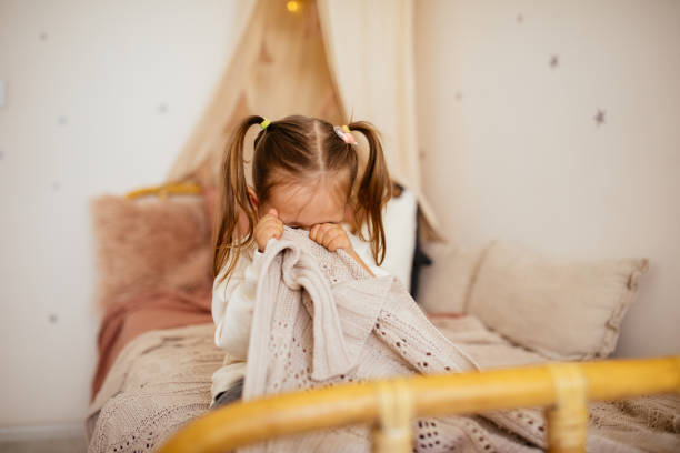 Crying little girl in bed stock photo
