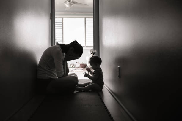 Crying, sad, and lonely mother with her baby at home stock photo