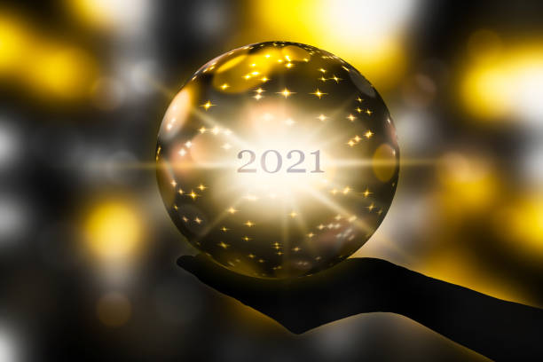 手にクリスタルボール、抽象的な光沢のあるぼやけた背景に新年2021の予測 - 水晶 ストックフォトと画像