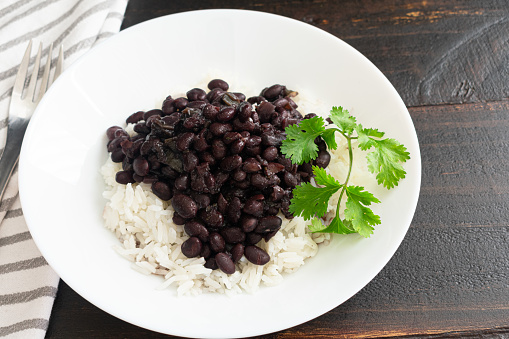 A plate of vegetarian beans and rice garnished with cilantro