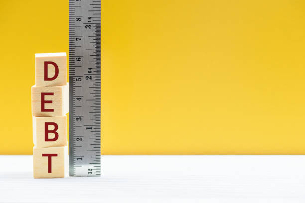 Cubes of debt and a ruler scale stock photo
