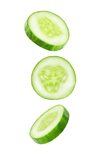Cucumber slices falling, hanging, flying, soaring isolated on a white background with clipping path. Full depth of field.