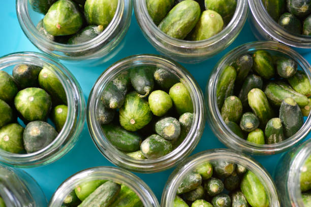 Cucumbers in a jars Cucumbers in a jars - preparing pickles - top view pickle stock pictures, royalty-free photos & images