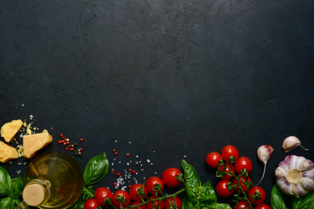 Culinary background with traditional ingredients of italian cuisine Culinary background with traditional ingredients of italian cuisine on a black slate, stone or concrete table. Top view with copy space. ingredient stock pictures, royalty-free photos & images