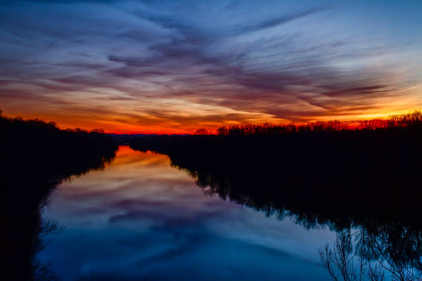 Cumberland Color Bueautiful colors in the sky reflected in the Cumberland River at the pedestrian bridge at Shelby bottoms Greenway in Nashville, Tennessee cumberland river stock pictures, royalty-free photos & images