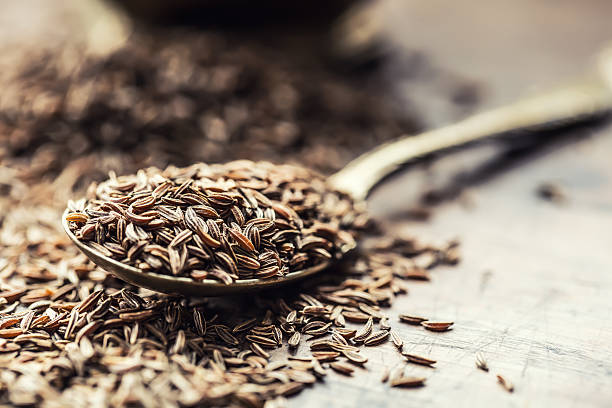 Cumin.Caraway seeds on wooden table. Cumin in vintage bowl. Cumin.Caraway seeds on wooden table. Cumin in vintage bronze bowl and spoon.Cumin.Caraway seeds on wooden table. Cumin in vintage bronze bowl and spoon. cumin stock pictures, royalty-free photos & images