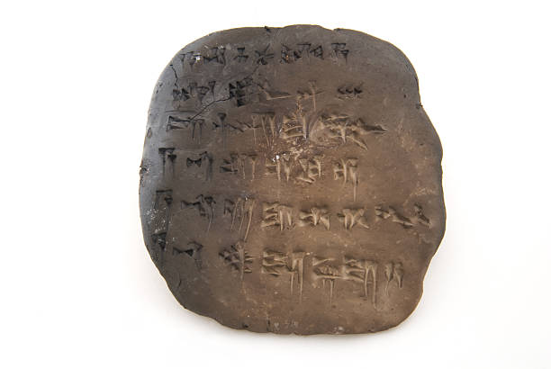 Cuneiform tablet isolated on white A tablet of cuneiform (ancient near/middle eastern "alphabet"). It is written in the Akkadian form telling the first few lines of the Descent of Ishtar to the underworld (Sumerian/Babylonian mythology) Artifact is baked clay, hence the charring on the left. Probably baked inadvertantly as the baking process is not complete or finished in a traditional glaze. Artifact is somewhat large indicating the writer has a limited proficiency with writing Akkadian. sumerian civilization stock pictures, royalty-free photos & images