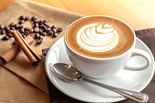 istock Cup of cafe' latte with coffee beans and cinnamon sticks 505168330