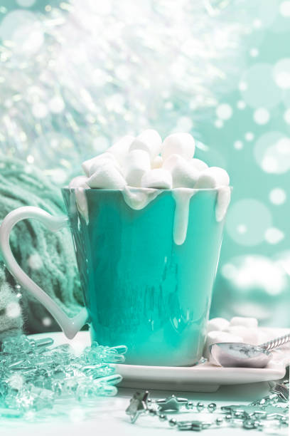 Cup of cocoa with cream with marshmallows, Christmas decor on background with bokeh in trendy color 2020 Aqua Menthe. Christmas festive decorations.Still life with cocoa or chocolate with cream and marshmallows and Christmas decor on background with bokeh in trendy color 2020 Aqua Menthe. Selective focus. aqua menthe photos stock pictures, royalty-free photos & images