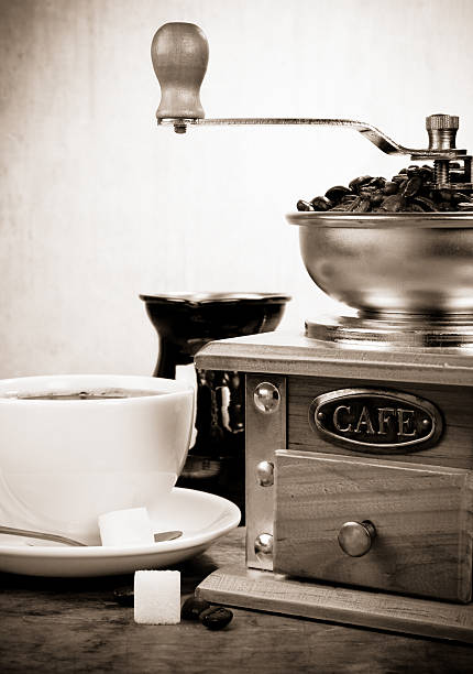 cup of coffee, beans and grinder on sepia