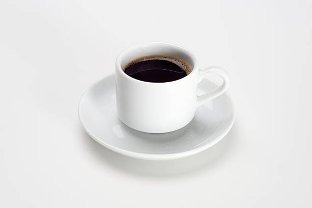 Cup of coffee over white background Black coffee with bubbles in white cup with saucer. black coffee stock pictures, royalty-free photos & images