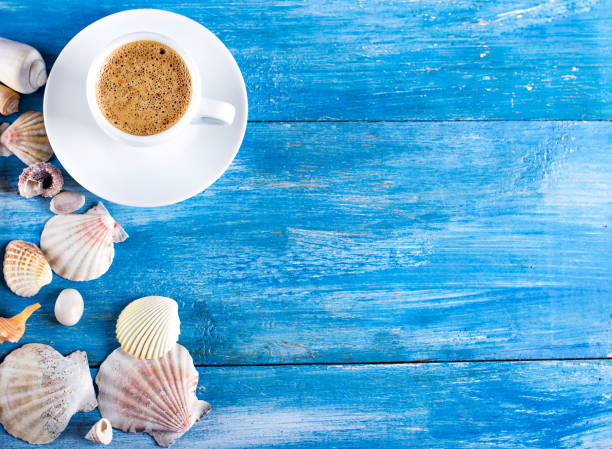 cup of coffee, shells, mobile phone on the old blue wooden boards
sea style. marine still life stock photo