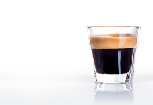 Close up of a glass of espresso on a black background