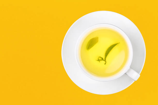 Cup of green oolong tea over yellow stock photo