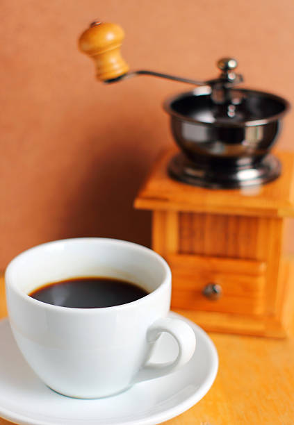 Cup of hot coffee with coffee grinder and beans
