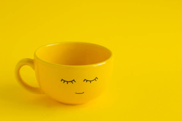 cup met schattige glimlach gezicht op een gele achtergrond - happy friday emoticon stockfoto's en -beelden