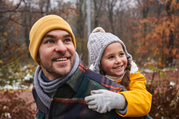Curious daughter admiring the beautiful nature in winter with her father on their Christmas vacation stock photo