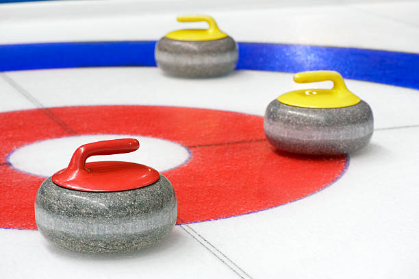 curling equipment laying on a bullseye - curling stockfoto's en -beelden