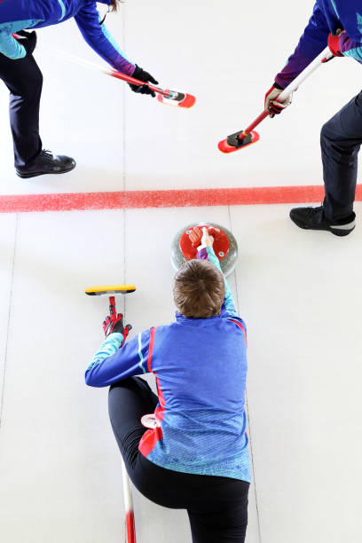 curling wedstrijd. jonge mensen op de ijsbaan. - curling stockfoto's en -beelden