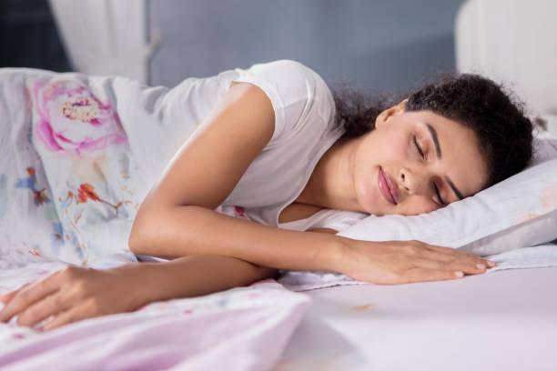 Curly hair woman is resting in bed stock photo