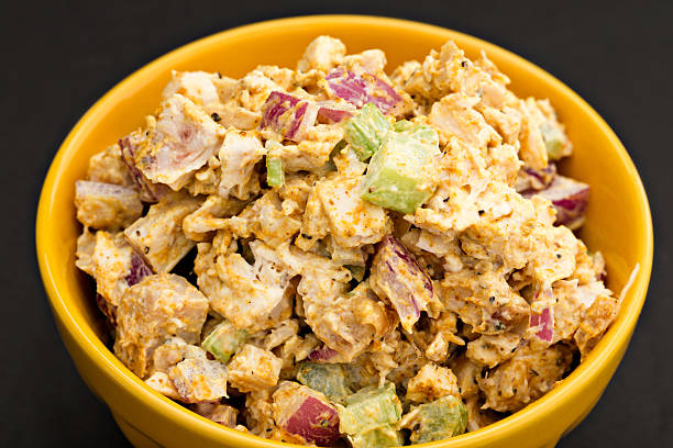 Curry Chicken Salad A high angle close up shot of a yellow bowl full of curry chicken salad. chicken salad stock pictures, royalty-free photos & images
