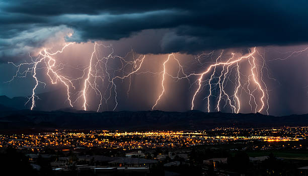 Curtain of Lightning Over City Multiple lightning strikes on a stormy evening near a city in southern Utah.  St. George, UT. thunderstorm stock pictures, royalty-free photos & images