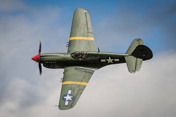 Curtiss P40 Warhawk Curtiss P40 Warhawk in flight against blue sky ww2 american fighter planes pictures stock pictures, royalty-free photos & images