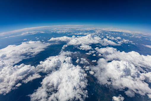 Curvature of planet earth. Aerial shot. Blue sky and clouds over land