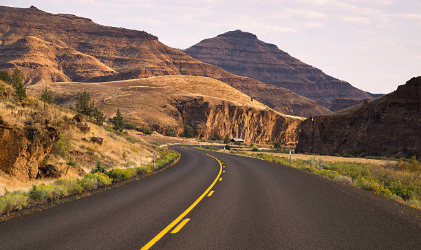 Curves Frequent Two Lane Highway John Day Fossil Beds One has to vist and drill down to really understand the expanse that is Oregon fossil site stock pictures, royalty-free photos & images